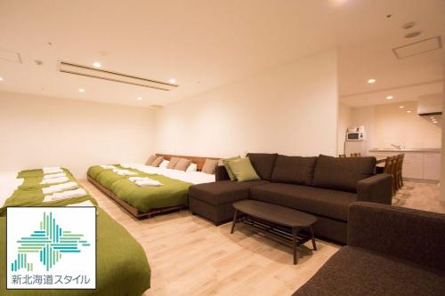 a living room with a couch and a bed at SEVEN Building / Vacation STAY 4949 in Asahikawa