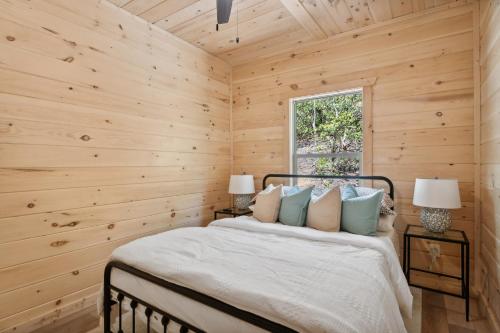 a bedroom with wooden walls and a bed with pillows at Baby Bear Den in Gatlinburg