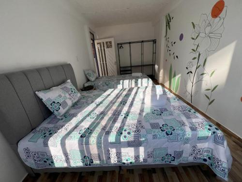 a bedroom with a large bed with a bedspread at NUEVO Hotel Morada en el centro del Eje Cafetero in Quimbaya