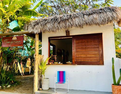 a small house with a thatch roof at Pousada Tangerina in Icaraí