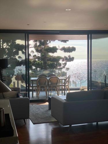 a living room with a couch and a table and chairs at PIER POINT 3 Bedroom Apartment with Bay Views on the Geelong Waterfront - 801 in Geelong