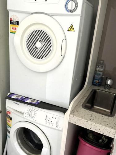a washing machine and a sink in a room at PIER POINT 3 Bedroom Apartment with Bay Views on the Geelong Waterfront - 801 in Geelong