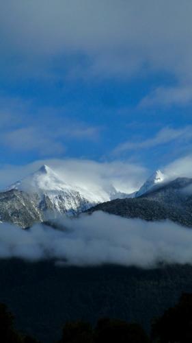 a snow covered mountain in the middle of a valley at Las Bandurrias Eco Hostal in Cochamó