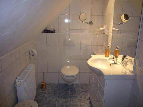 a white bathroom with a sink and a toilet at Hotel Ovelgönner Hof in Buxtehude