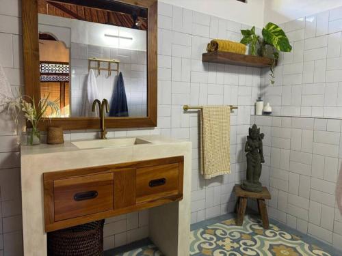 ein Badezimmer mit Waschbecken und Spiegel in der Unterkunft Indah puri Bali Bungalow on Candidasa beach in Candidasa