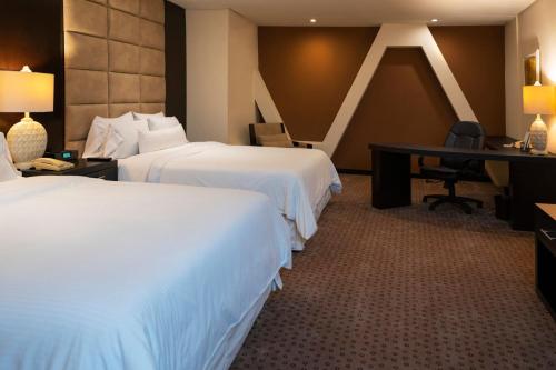 a hotel room with two beds and a desk at The Westin Camino Real, Guatemala in Guatemala