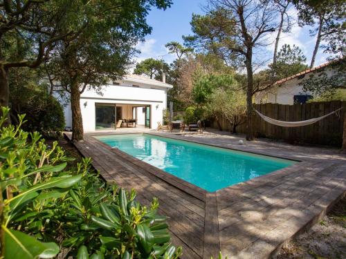 - une piscine avec un hamac dans l'arrière-cour dans l'établissement Villa rénovée avec spa et piscine chauffée à Hossegor, proche plage et golf - FR-1-791-8, à Soorts-Hossegor