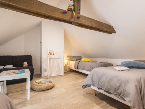 a attic room with two beds and a couch at Gîte chaleureux à Assérac, proche mer, jardin privé, wifi - FR-1-306-1285 in Assérac