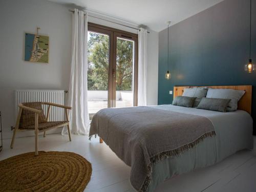 une chambre avec un lit, une chaise et une fenêtre dans l'établissement Villa rénovée avec spa et piscine chauffée à Hossegor, proche plage et golf - FR-1-791-8, à Soorts-Hossegor
