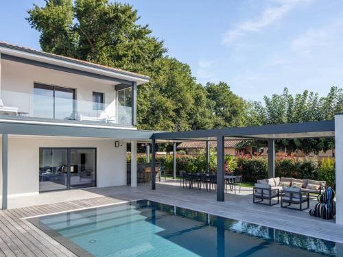 une maison avec une piscine et une terrasse dans l'établissement Villa sublime avec piscine chauffée, SPA et sauna à 10 min de la plage et des golfs - FR-1-791-19, à Tosse