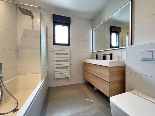 une salle de bain avec une baignoire, un lavabo et une douche dans l'établissement Villa à Capbreton avec Piscine Chauffée, Proche Plages, Pistes Cyclables et Services Hôteliers Inclus - FR-1-791-7, à Capbreton