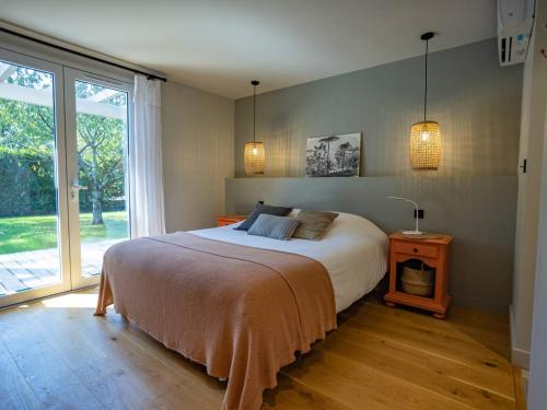 une chambre avec un lit et une grande fenêtre dans l'établissement Villa Rénovée à Hossegor avec Piscine Chauffée, Proche Golf et Plage - FR-1-791-15, à Soorts-Hossegor