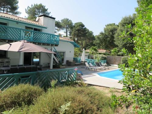 une maison avec une piscine dans la cour dans l'établissement Spacieuse villa au golf avec piscine privée, parking, et services de conciergerie - FR-1-791-23, à Seignosse