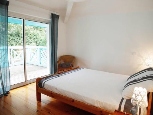 une chambre avec un lit et une grande fenêtre dans l'établissement Spacieuse villa au golf avec piscine privée, parking, et services de conciergerie - FR-1-791-23, à Seignosse