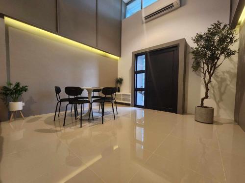 a dining room with a table and chairs and a tree at Chiangrai Airport, Private & Cozy house in Ban Du