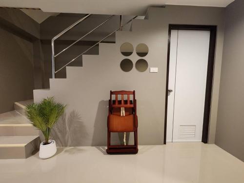 a room with a staircase with a chair and a plant at Chiangrai Airport, Private & Cozy house in Ban Du