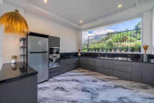 a kitchen with a marble floor and a large window at Adara Lake View Residence Bedugul - Bali in Bedugul