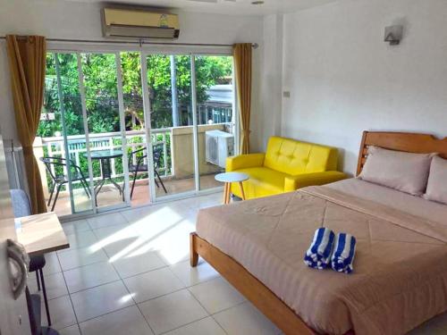 a bedroom with a bed and a yellow chair at K2 Seaside Suites in Pattaya South