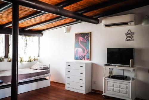 a bedroom with a bed and a television in a room at Casa na Vila T1 in Fuzeta