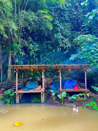 two people sleeping on beds in a river at Villa Robert in Pineleng