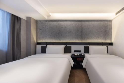 zwei Betten in einem Zimmer mit zwei Betten sidx sidx sidx in der Unterkunft Atour Light Hotel Nanjing Museum in Nanjing