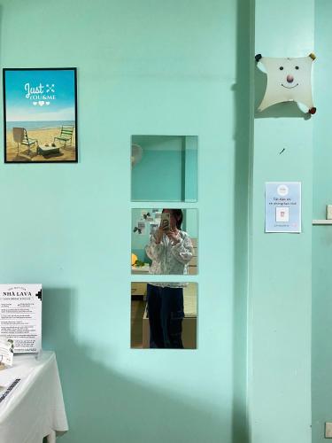 a woman taking a picture of herself in a mirror at Lava Homestay Hải Phòng in Hai Phong