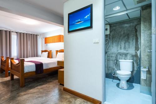 a hotel room with a bed and a toilet at XX GO INN Khaosan Road - Grand Palace in Bangkok