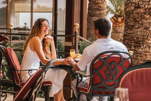 a man and woman sitting at a table holding hands at Castillo Hotel Son Vida, a Luxury Collection Hotel, Mallorca in Palma de Mallorca