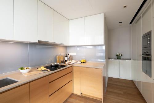 a kitchen with white cabinets and wooden counters at Lanson Place Bukit Ceylon in Kuala Lumpur