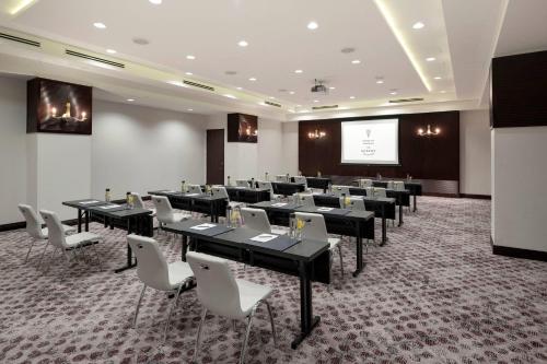 a conference room with tables and chairs and a projection screen at Hotel Ivy, a Luxury Collection Hotel, Minneapolis in Minneapolis