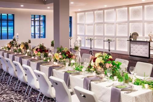 a long banquet table with white chairs and flowers at Hotel Ivy, a Luxury Collection Hotel, Minneapolis in Minneapolis