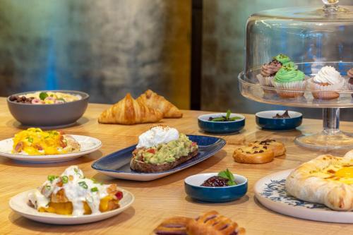 a table topped with plates of food and pastries at Le Meridien Batumi in Batumi