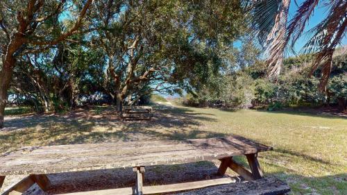a wooden picnic table in a park with trees at ALWAYS TURTLE CRAWL home in Jekyll Island