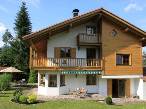 a log house with a balcony and a patio at Ferienhaus Hirschwiesn -565- in Krün