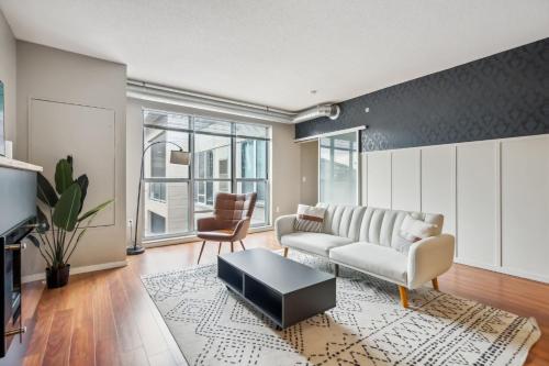 a living room with a couch and a table at CozySuites 2BR Mill District with gym # 01 in Minneapolis