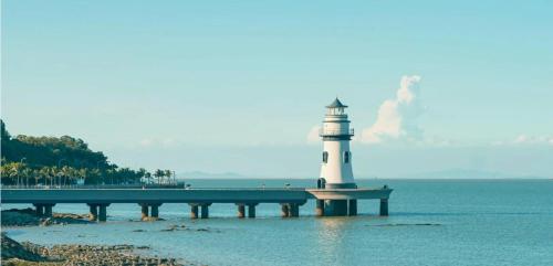 a lighthouse sitting on a pier in the water at Slow Cloud Residence - Gongbei Port Zhuhai Station in Wan-tzu