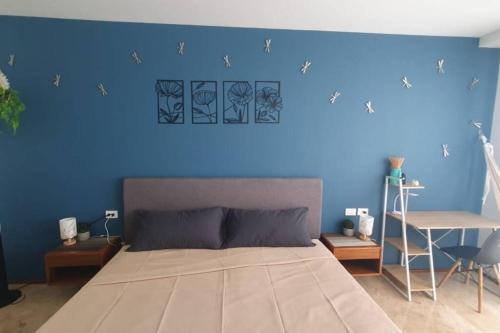 a blue bedroom with a bed and a blue wall at Estudio de playa Monpal in Playa del Carmen