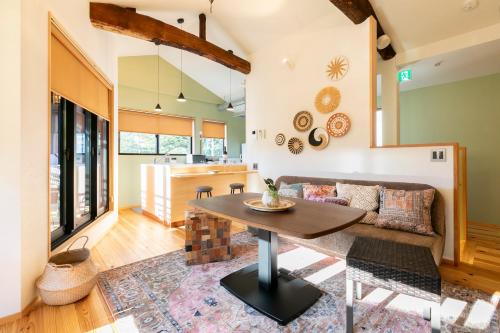 a living room with a table and a couch at IROHA STAY Kyoto 麗 -Rei- in Kyoto