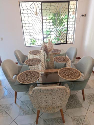 a dining room table with chairs and a glass table at Casa la Estancia 2 in Tena