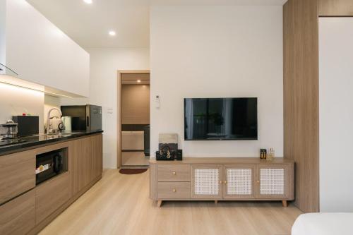 a living room with a flat screen tv on a wooden entertainment center at Lux Apartment Ngọc Khánh 2 in Hanoi