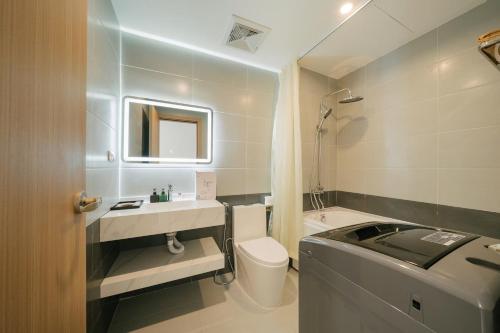a bathroom with a toilet and a sink and a tub at Lux Apartment Ngọc Khánh 2 in Hanoi