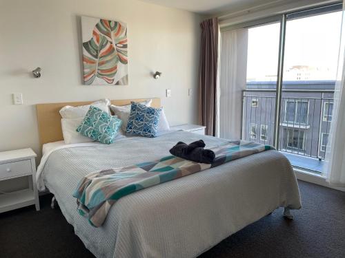a bedroom with a large bed with a large window at Apartment in the heart of the city in Christchurch