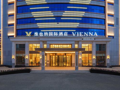 a building with a sign on the front of it at Vienna International Hotel Classic version of Shangzhi Dongpu Building in Shangzhi