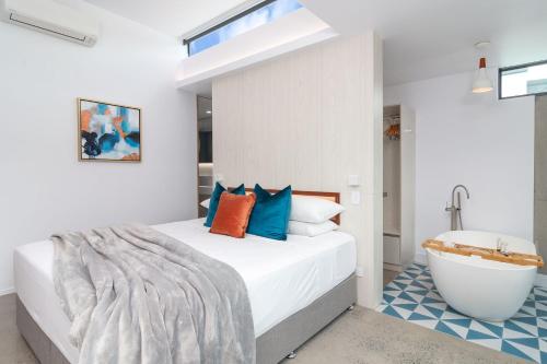 a bedroom with a bed and a bath tub at Aria Villa 2 Port Douglas in Port Douglas