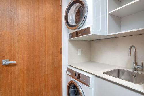 a kitchen with a washing machine and a sink at Aria Villa 2 Port Douglas in Port Douglas