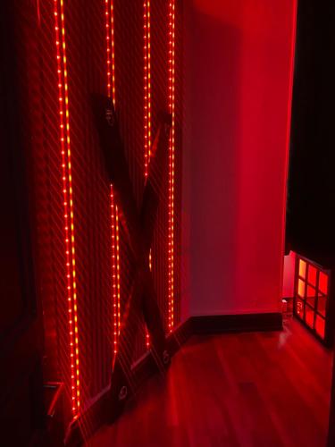 Cette chambre est dotée de lumières rouges sur le mur. dans l'établissement Love apparemment, à Metz