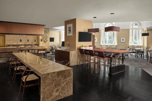 a kitchen and dining room with a bar and chairs at Sydney Harbour Marriott Hotel at Circular Quay in Sydney