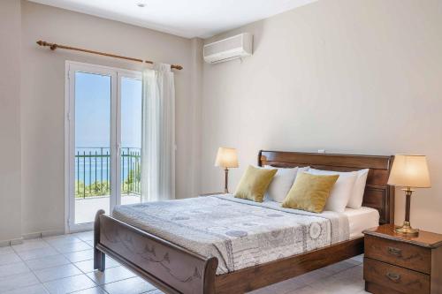 Un dormitorio con una cama y una ventana grande. en Villa Mihas, en Vlachata