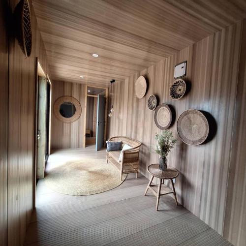 a hallway with a chair and plates on the wall at Elephant lodge in Kwa Kuchinia