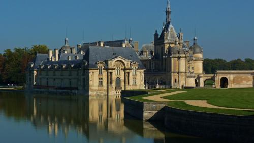 a large castle sitting on top of a body of water at Relais De La Haute Pommeraye in Apremont